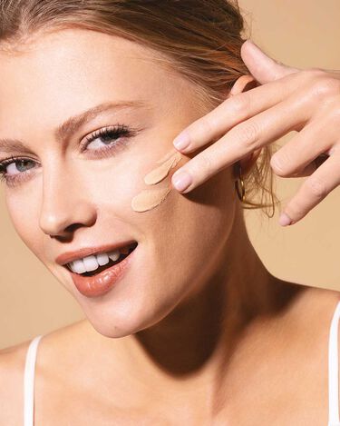 model putting Maria Galland foundation on her cheek